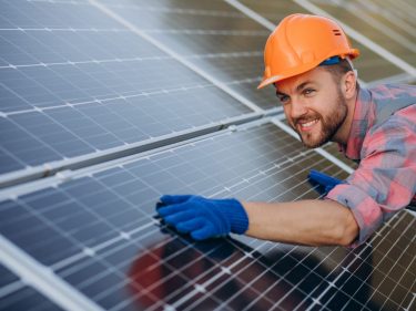 Male worker cleaning solar panels